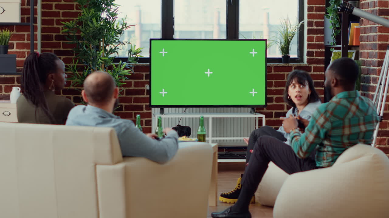 Group of people using greenscreen on tv to play video games