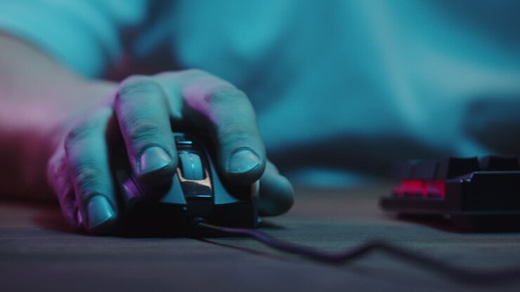 Primo piano di una mano che clicca e scorre un mouse del computer con luci al neon