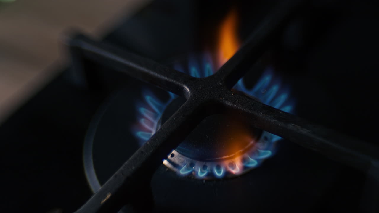 세라 ⁇  검은색 가스 스토브에 있는 핫 ⁇ 의 왜곡된 클로즈업이 불타고 잠시 동안 불타고 꺼지고 있습니다.