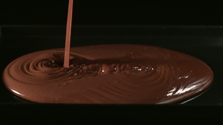 Mixing chocolate cubes with Fine cocoa powder, on a black background, Mixing with a silver bowl-1