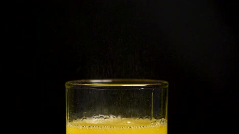 orange juice splashing into glass