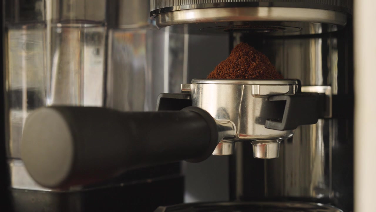 Chicchi di caffè macinati su un portafiltro per espresso.