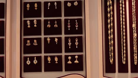 panning shot of arranged gold jewelry or jewellery at showroom - concept of greedy, luxury, wealth and dreaming for gold