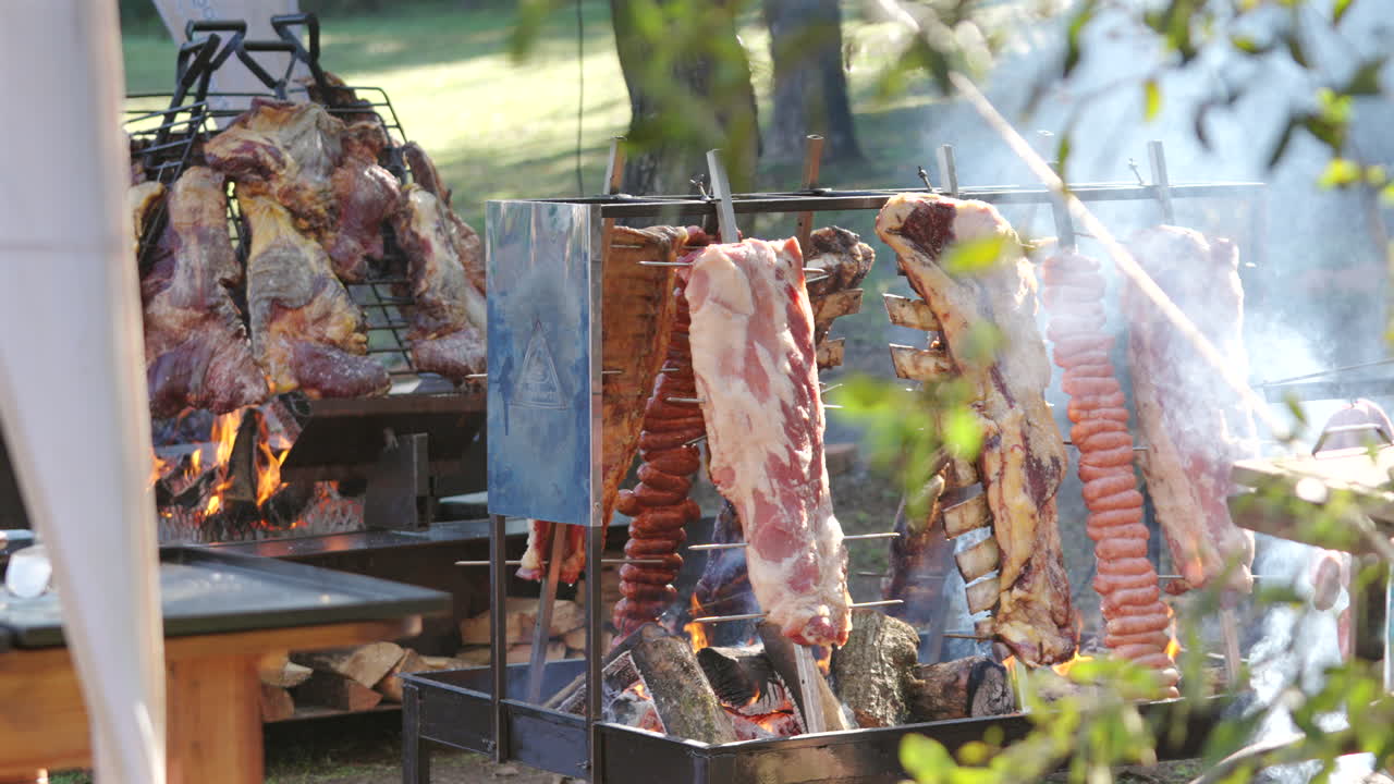 Roasting beef ribs on grills at rural Argentine barbecue, latin american food culture