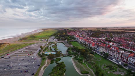 el video aéreo captura la belleza de una tranquila puesta de sol en skegness, una encantadora ciudad costera en el reino unido, con un enfoque en la ciudad, el paseo marítimo, el muelle y la costa