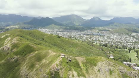 Aerial-Mountain-view-with-suburban-city-and-mountain-range-in-background-on-a-tropical-island