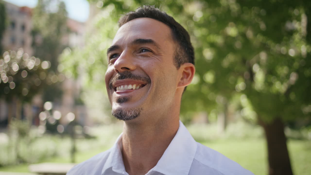 Happy man posing park portrait. Brunette businessman face looking camera closeup