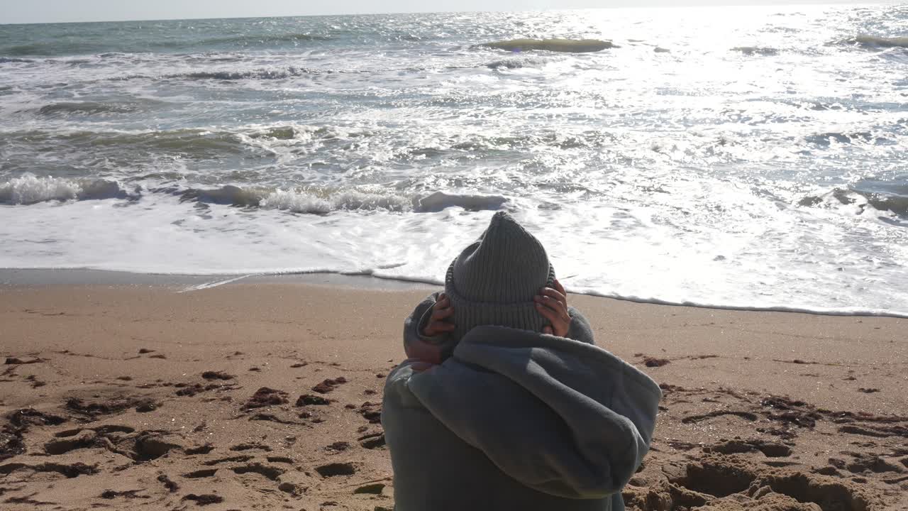 해변에 앉아서 바다를 바라보고 있는 사람