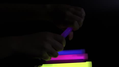 manos activando y arreglando palos brillantes de colores