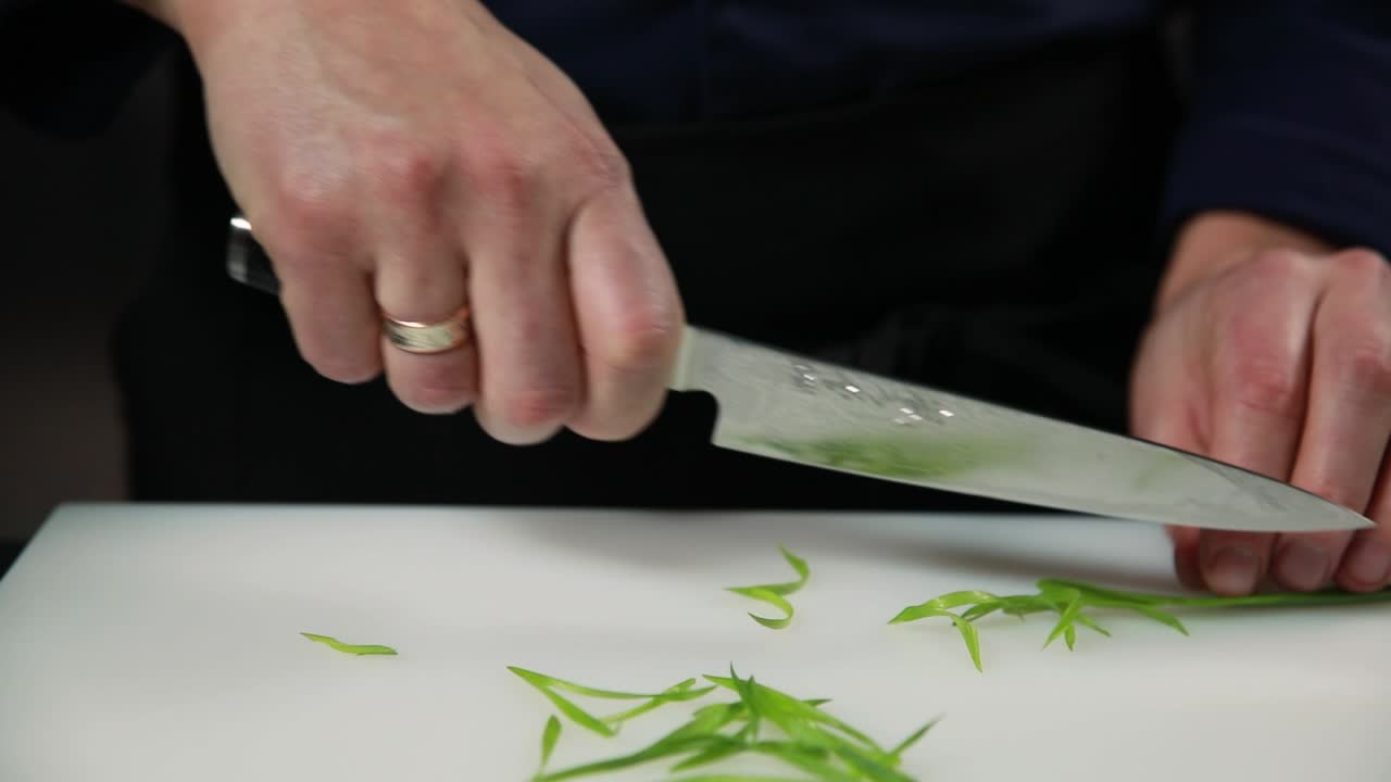 셰프가 초록 양파를 고 있습니다.