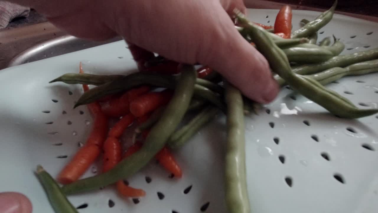 싱크대에서 직접 재배한 유기농 채소를 손으로 씻는 남성