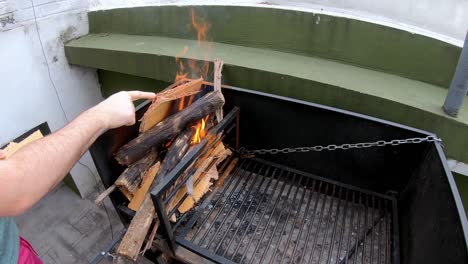 Slow motion video of a white man lighting the fire with paperboard to grill on a sunny day