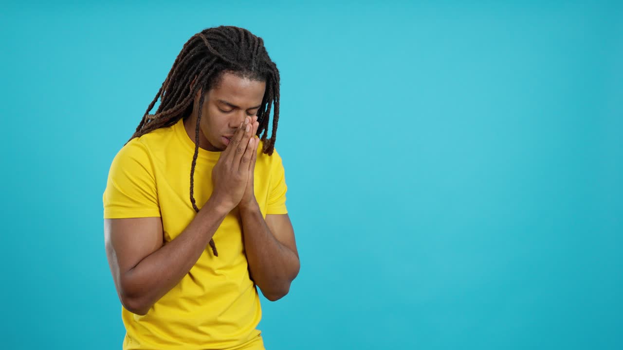 Uomo in preghiera con i dreadlocks