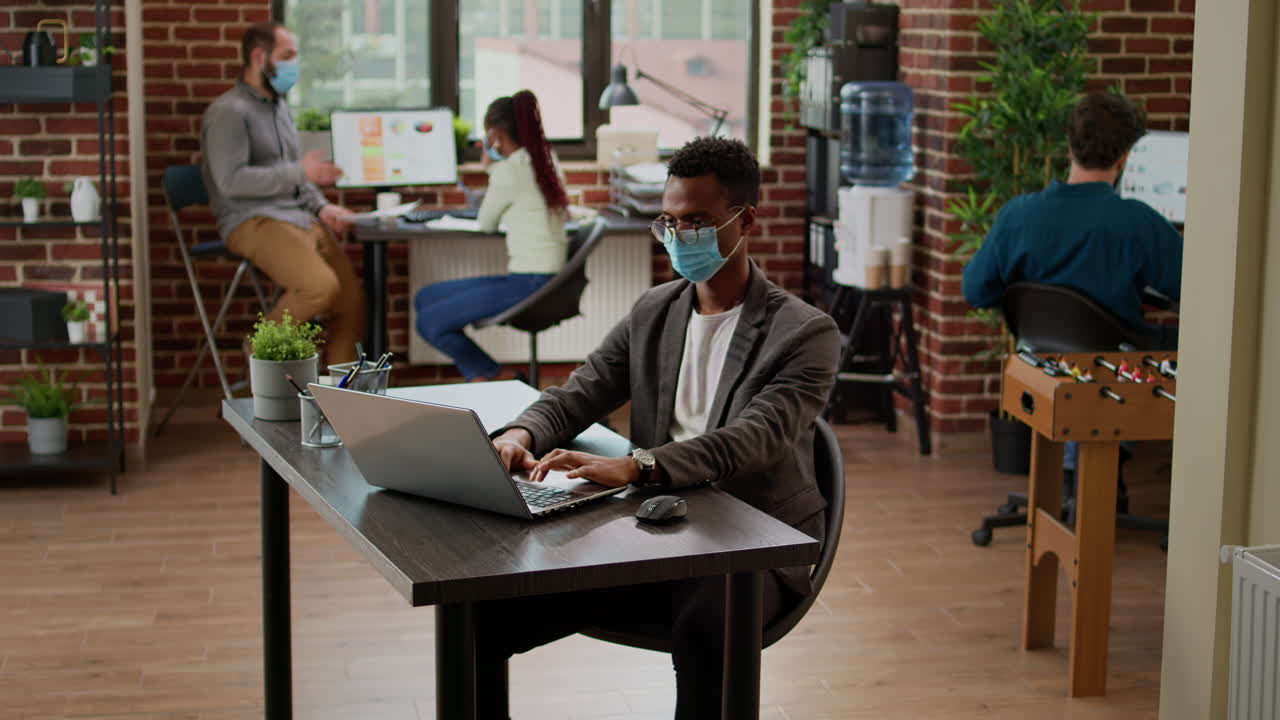 African american businessman working on laptop at office desk