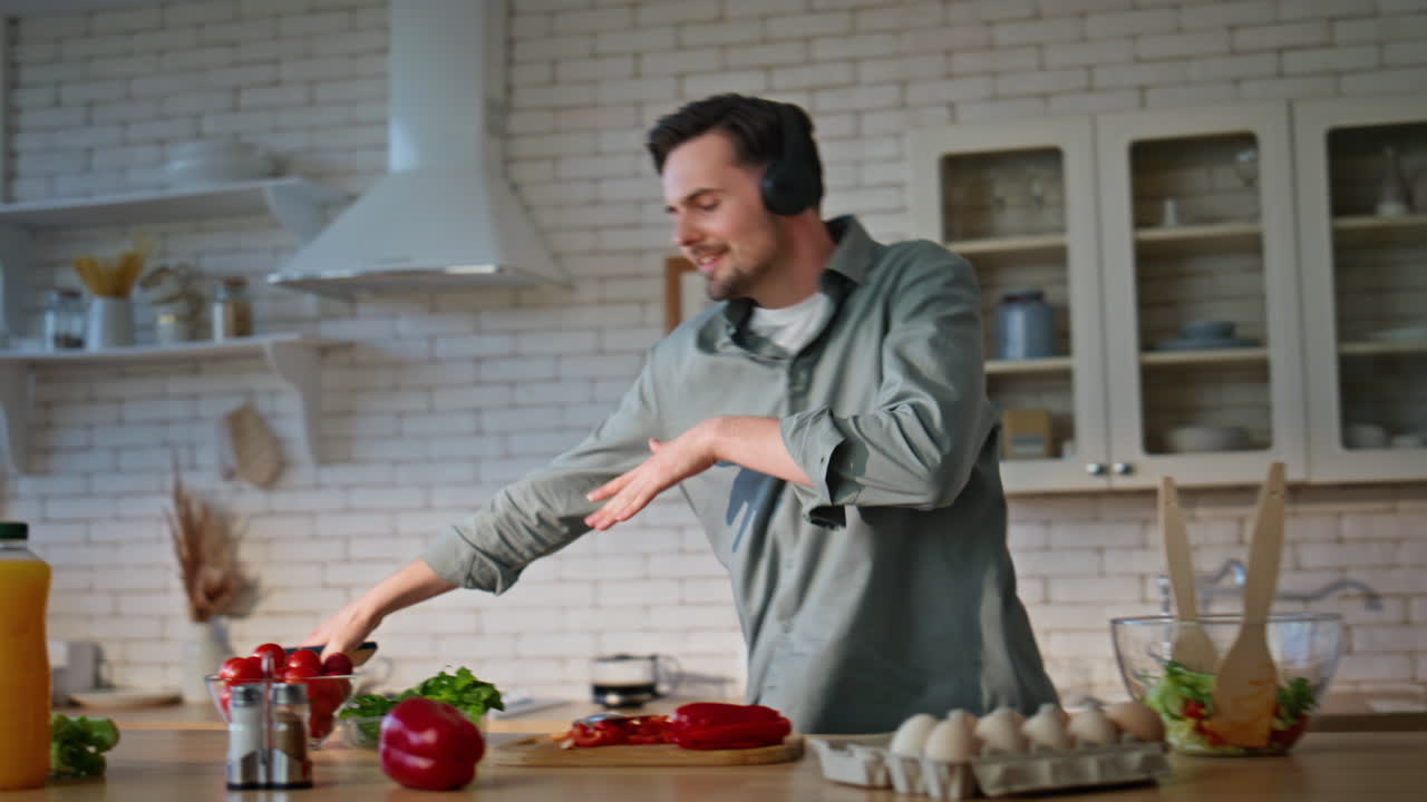 Man hand turning smartphone music in cuisine closeup. Happy guy listening song