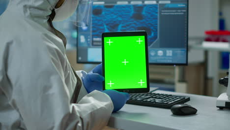 chemist man wearing protection suit holding tablet with green mockup