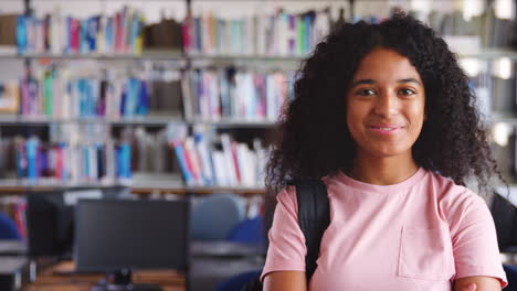 portrait of female student standing in college library