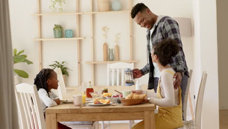 Happy-african-american-parents-and-daughter-having-breakfast-at-home,-slow-motion