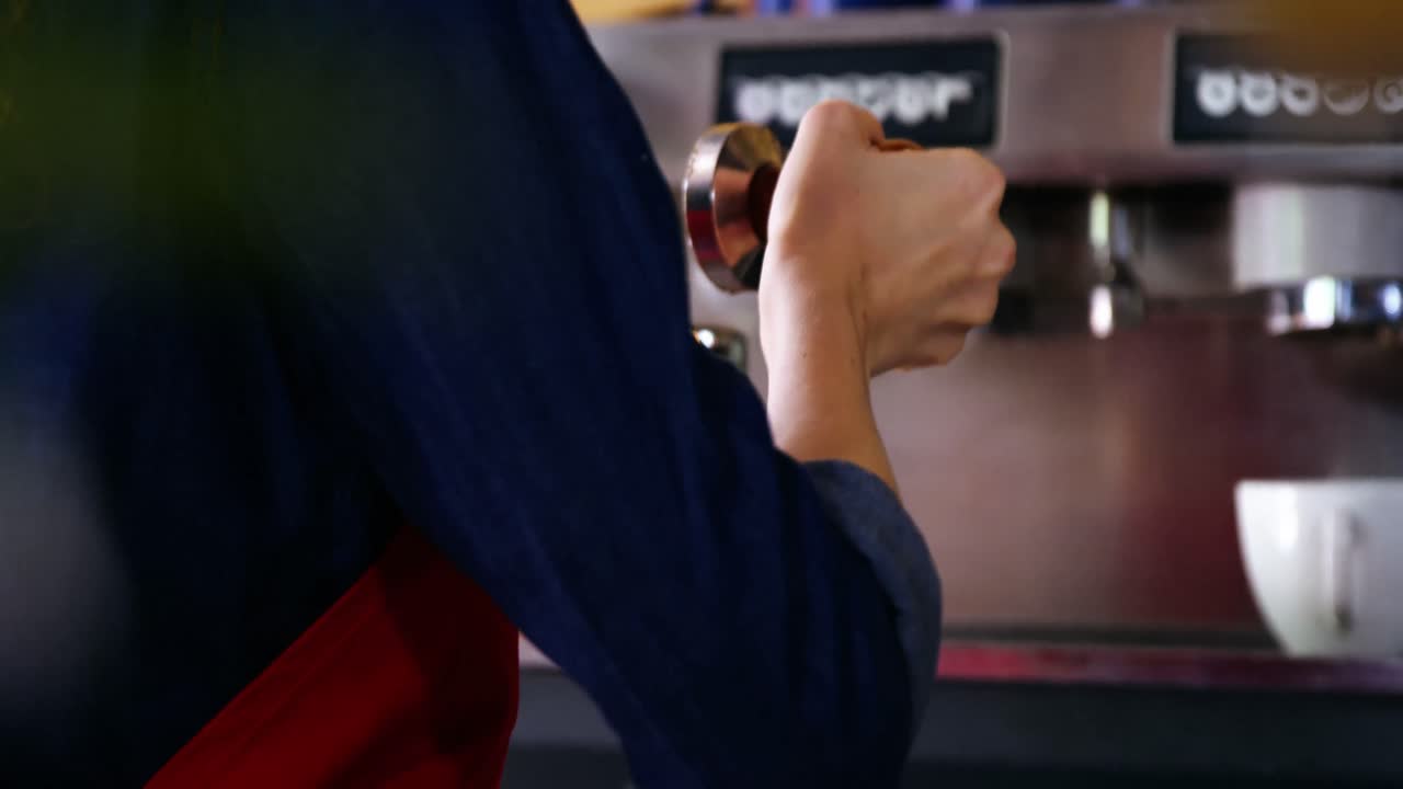 포타 필터에  ⁇ 은 커피를  ⁇ 러기 위해  ⁇ 퍼를 사용하는 웨이트리스