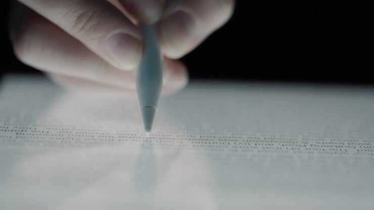 Close up of a pen highlighting text on a tablet