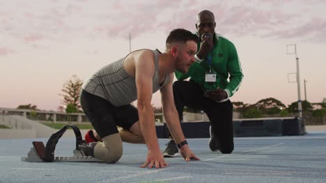 entrenador masculino diverso y atleta discapacitado con entrenamiento de hoja de correr al atardecer