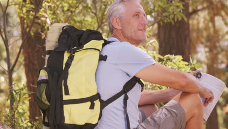 Thoughtful-hiker-sitting-with-map