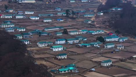 drone view of phortse village along everest base camp trek, showing rural himalayan lifestyle, farmlands, distant peaks, and scenic terrain lands