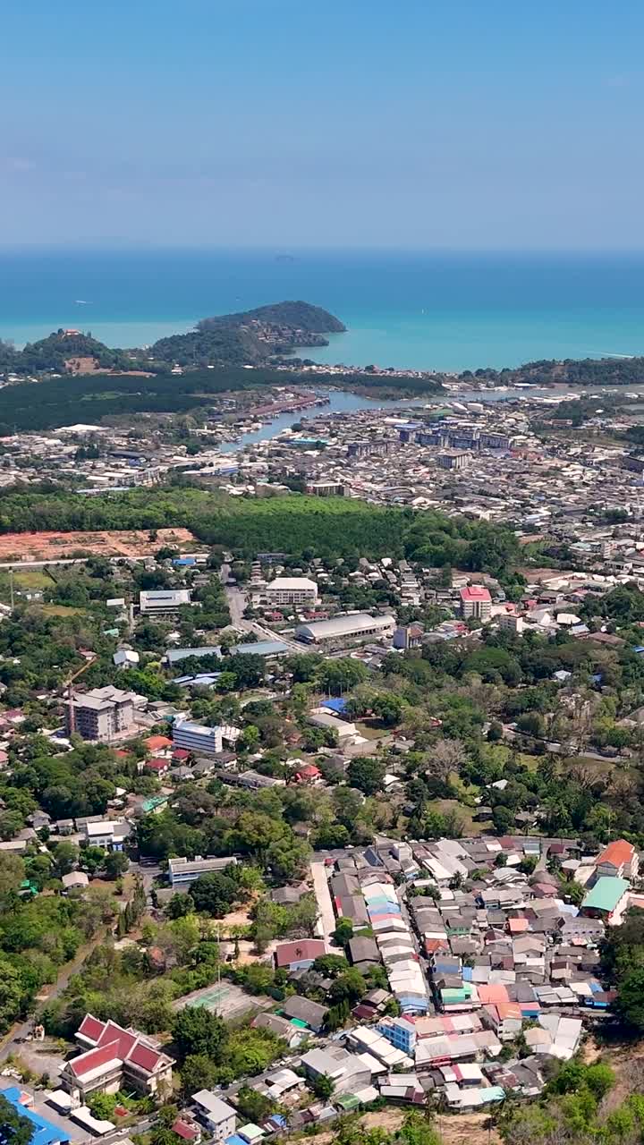 Drone footage captures Phuket's vibrant cityscape and stunning coastline under clear skies, highlighting the Andaman Sea's beauty