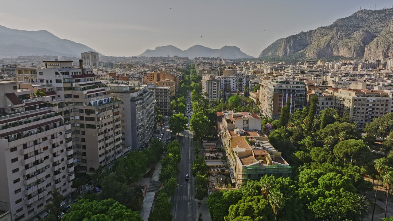 palermo, italia, vuelo aéreo v10 de drones bajos sobre la vía principal de la via della liberta capturando el tráfico callejero, el paisaje urbano residencial, la plaza de la ciudad y las vistas montañosas - filmado con mavic 3 cine - mayo 2023