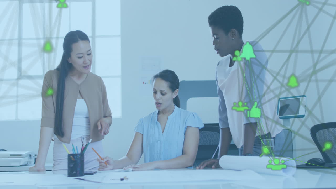 Animation of connected icons forming globe over diverse female architects discussing blueprint
