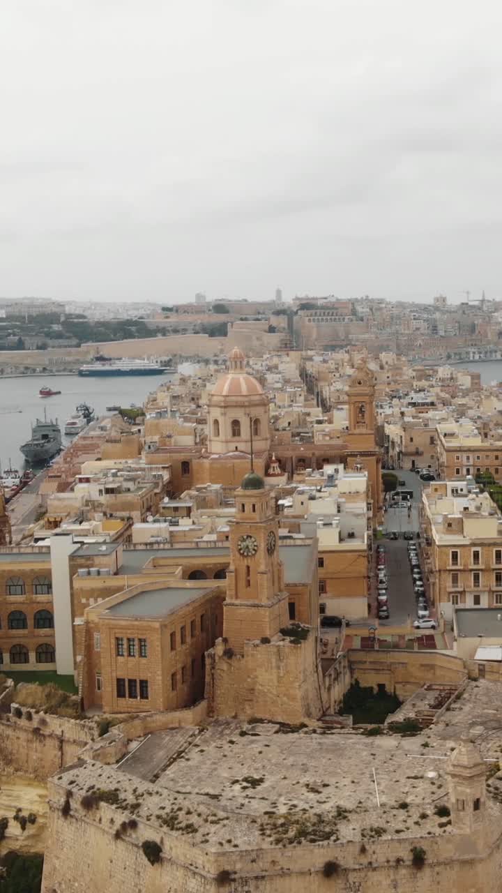 Aerial view of senglea basilica and harbour skyline in malta vertical