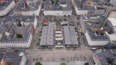 Flying-over-Torvehallerne-during-midday,-surrounded-by-people-and-cars,-in-the-heart-of-Copenhagen