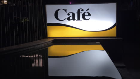 Beleuchtetes-Café-Banner-In-Der-Nacht