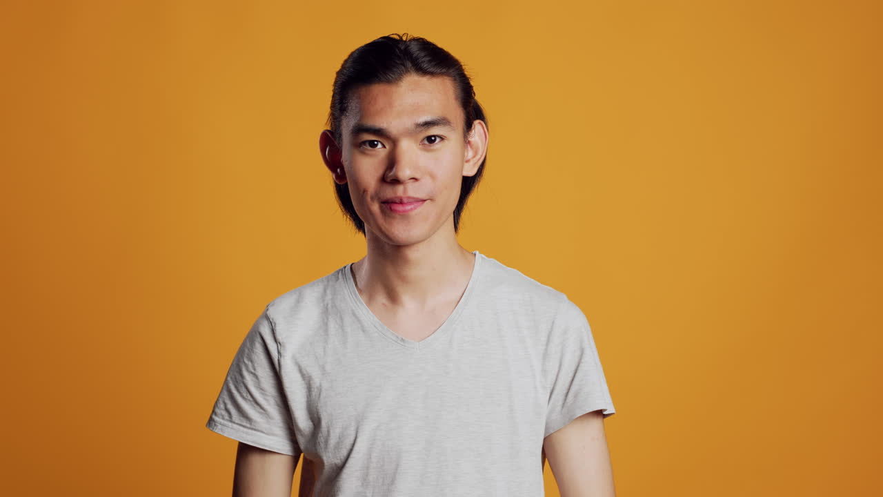 Cheerful young guy showing phone with greenscreen
