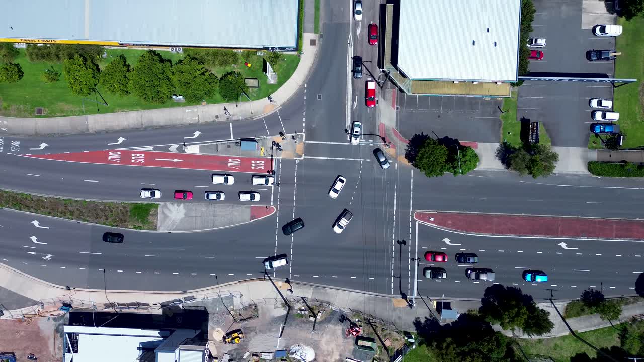 Drone aerial landscape of car vehicle traffic turning at busy intersection traffic lights in rural town Tuggerah Central Coast Australia tourism travel transport urban infrastructure