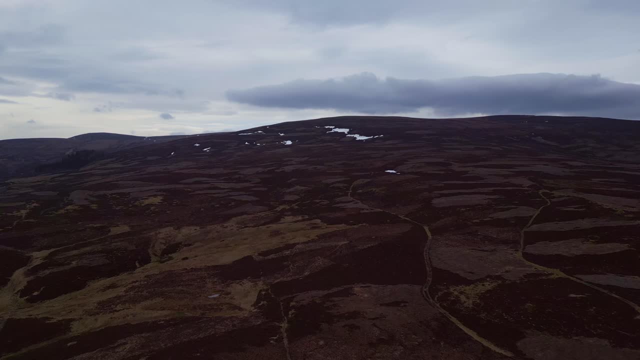 volando alto sobre las tierras altas escocesas en un día nublado con vistas panorámicas de los majestuosos lagos en el fondo