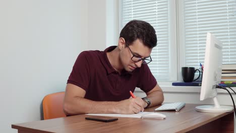 Joven-Oficinista-Con-Gafas-Tomando-Notas-En-El-Papel,-Luego-Cometiendo-Un-Error,-Arrugándolo-Y-Tirándolo-A-La-Basura.-Filmado-En-4k