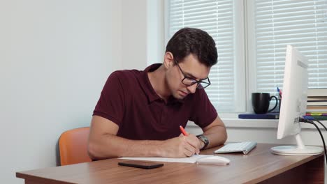 joven empleado de oficina con gafas haciendo notas en el pedazo de papel, luego cometiendo un error, arrugándolo y arrojándolo a la basura. filmado en 4k