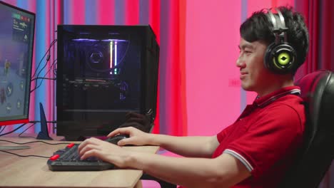 asian man playing survival shooter games on computer