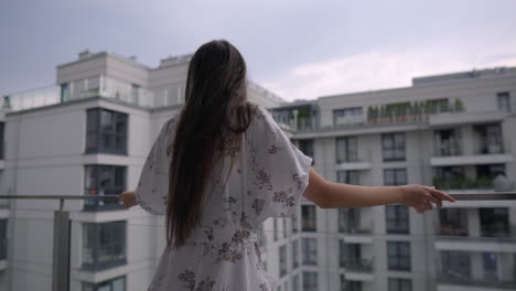 mujer en el balcón contemplando el paisaje de la ciudad