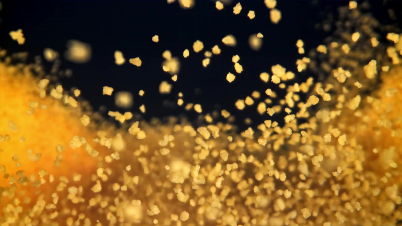 Scintillanti particelle di polvere d'oro che si alzano su sfondo nero