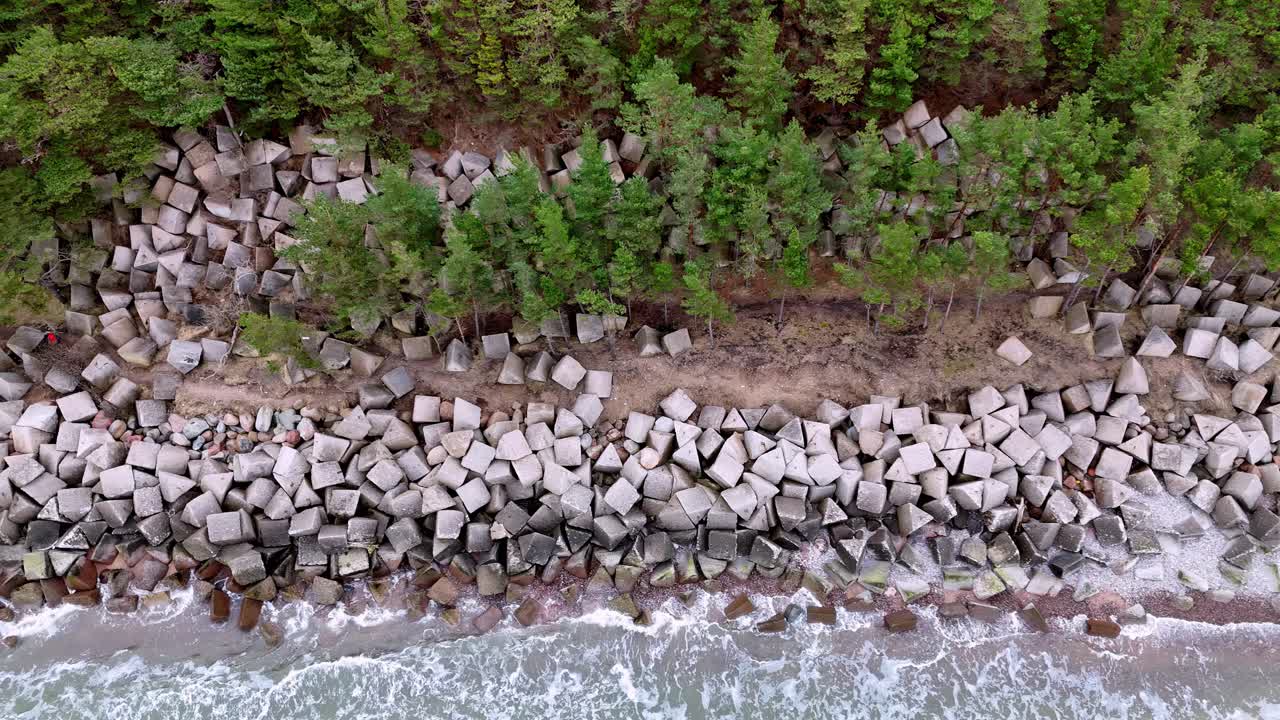 Topudsigt over havmure af stenblokke i Uzava, Østersøen, Letland