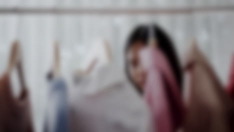 Blurred-close-up-shot-of-woman-shopping-for-clothing