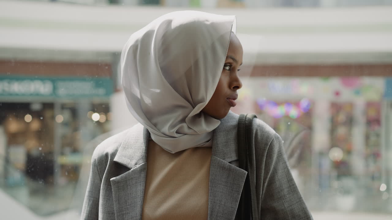 African-American woman in hijab turns head on elevator