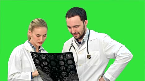 colaboración médica examinar rayos x y discutir los problemas del paciente en una pantalla verde, llave de croma