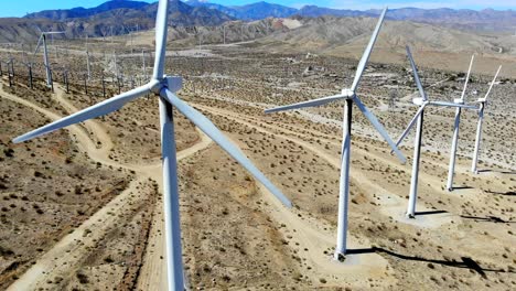 Windmills,-wind-turbines,-aerial-4k-drone-slow-pull-back,-energy,-green,-renewable,-huge-power-generating-farm-on-desert-hills,-Mt-San-Gorgonio-in-BG-in-Palm-Springs,-Coachella-Valley,-Cabazon,-Calif