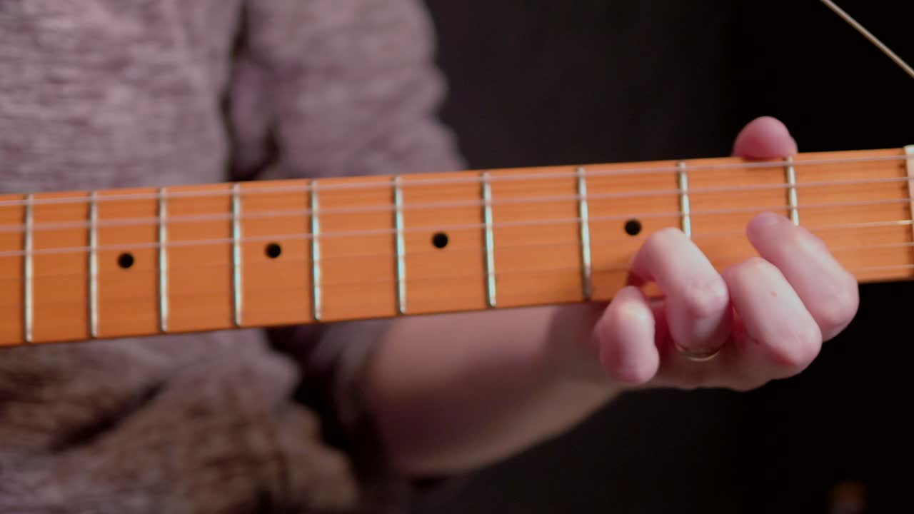 una mujer tocando acordes de guitarra