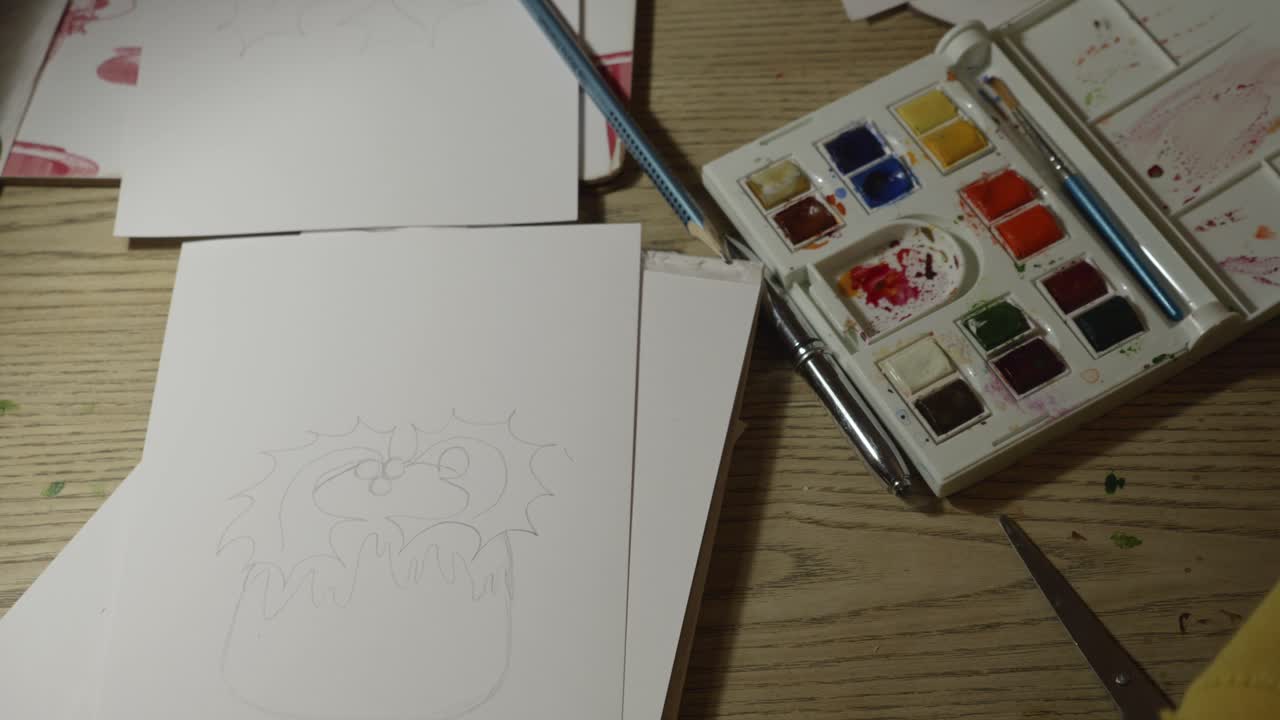 cerca de manos femeninas mezclando colores, preparándose para pintar una tarjeta de navidad