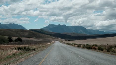 driving on a scenic open road with mountains