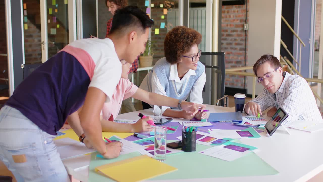 Diverse male and female creative colleagues in discussion in casual meeting, slow motion
